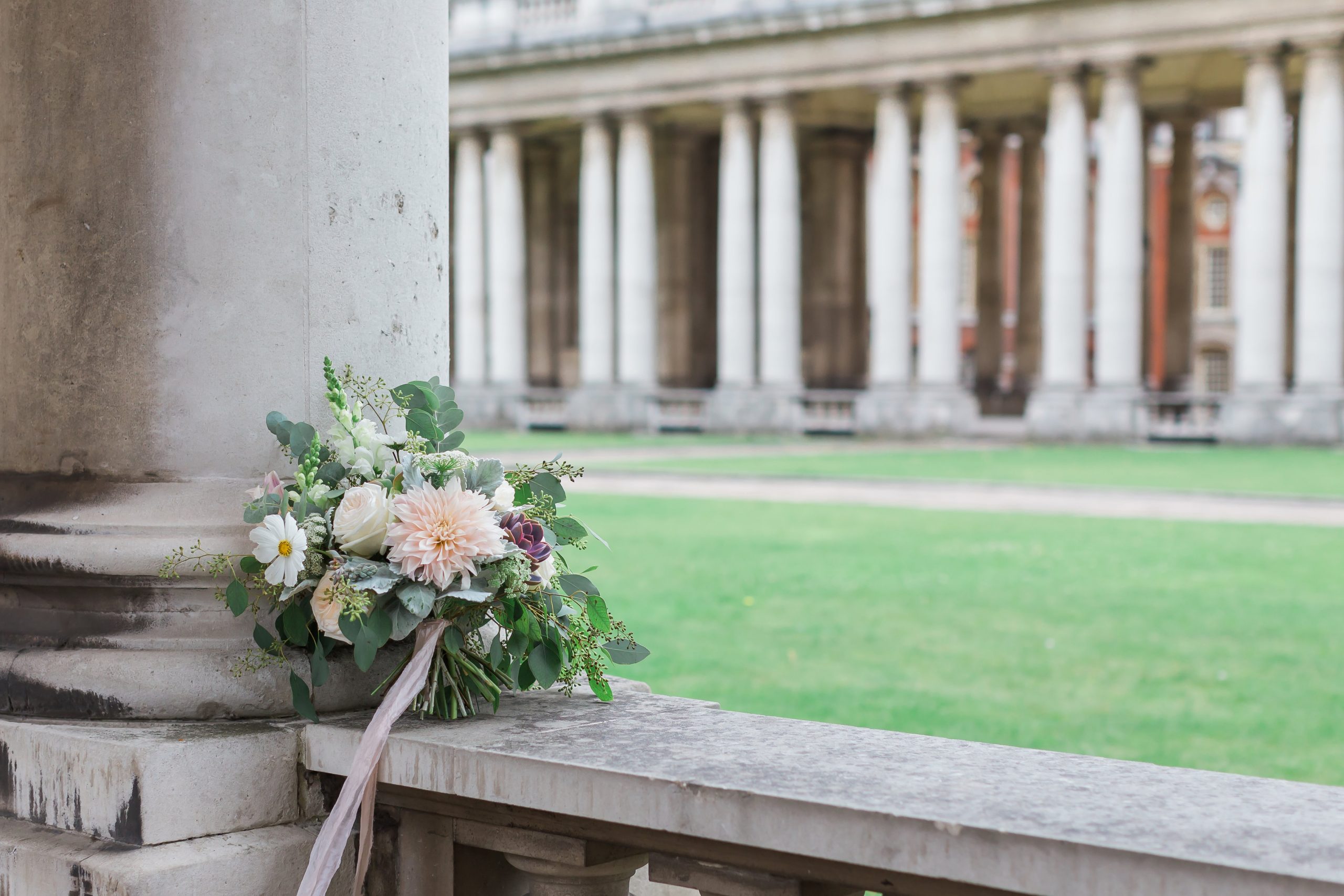 image of a bridal bouquet sitting on a wall with stone columns behind